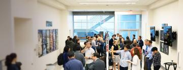 Researchers socializing and presenting posters